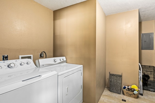 laundry room featuring separate washer and dryer, laundry area, a textured ceiling, and electric panel
