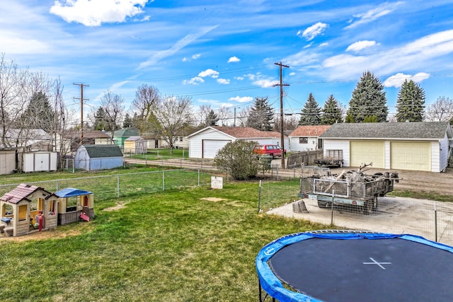 view of yard featuring fence, an outbuilding, and a trampoline