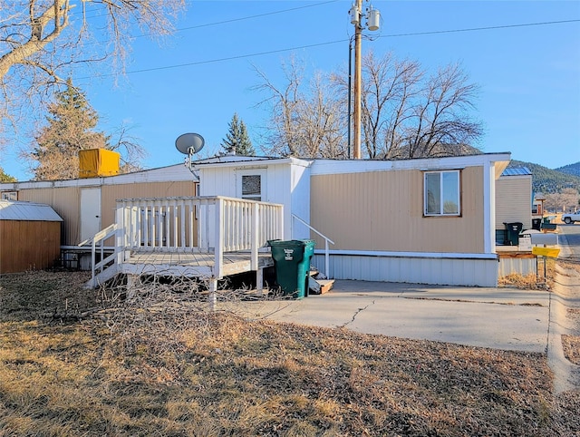 rear view of property featuring a wooden deck