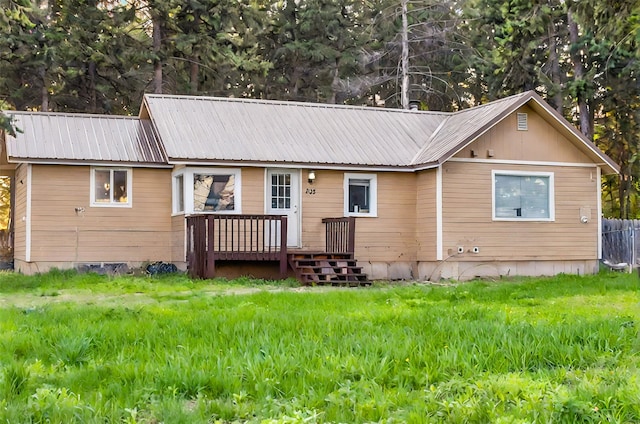 single story home with metal roof and a wooden deck