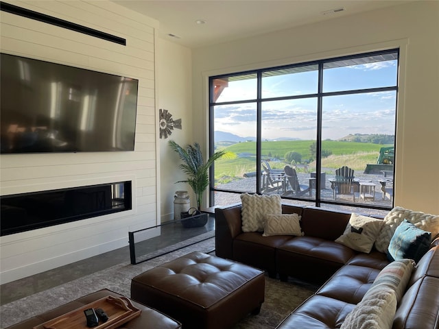 living area featuring visible vents, wooden walls, and a large fireplace