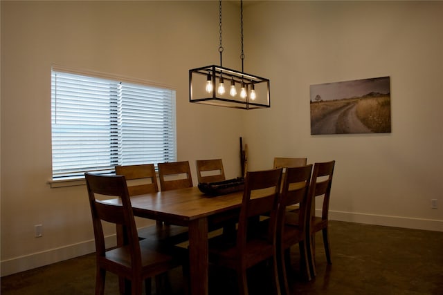 288 Costich Lake Rd, Eureka, MT 59917 - dining area featuring baseboards, a notable chandelier, and concrete floors