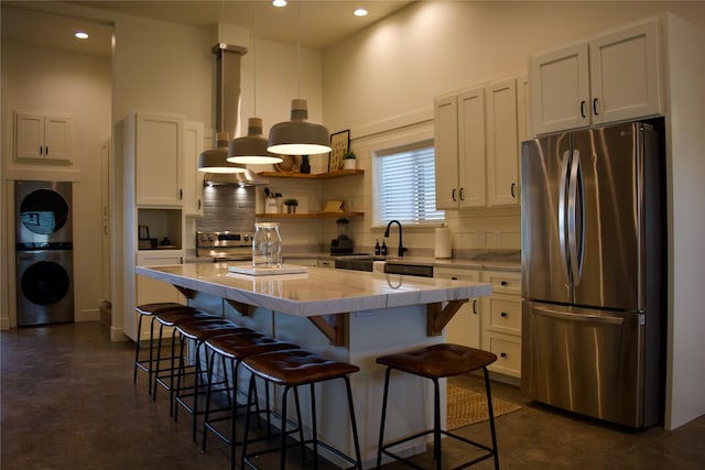 288 Costich Lake Rd, Eureka, MT 59917 - kitchen featuring a sink, finished concrete flooring, a center island, stainless steel appliances, and backsplash