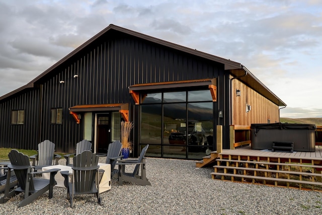 288 Costich Lake Rd, Eureka, MT 59917 - back of house featuring a hot tub, board and batten siding, and a wooden deck