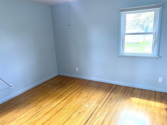 empty room featuring wood-type flooring and baseboards