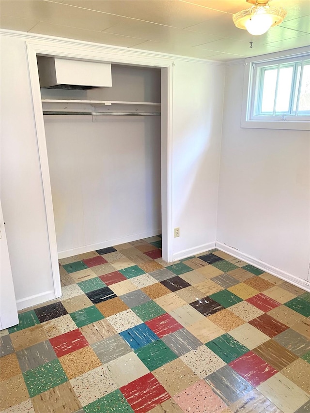unfurnished bedroom with a closet, baseboards, and tile patterned floors