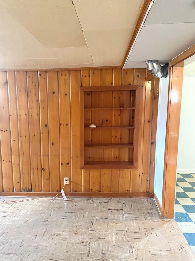 basement featuring baseboards and wood walls