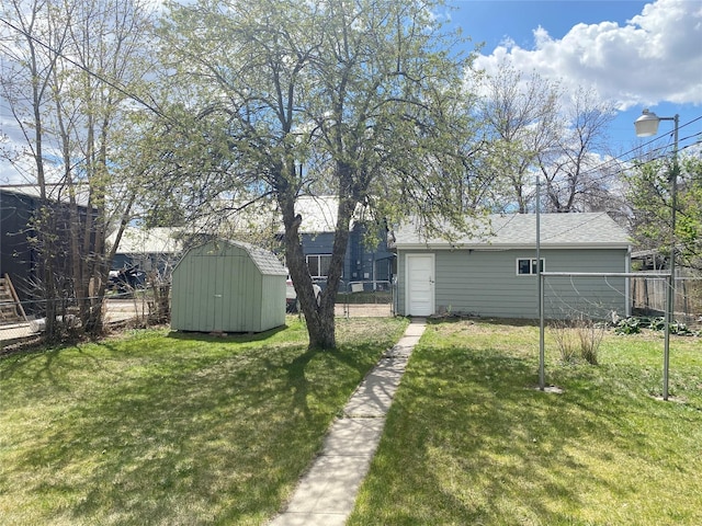 view of yard featuring fence, an outbuilding, and a shed