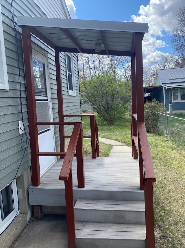 deck featuring a lawn and fence