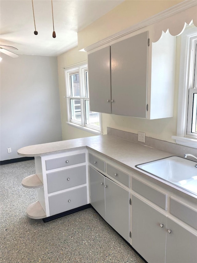 kitchen with light countertops, open shelves, a sink, and ceiling fan