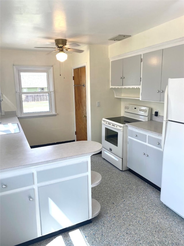 kitchen featuring visible vents, a ceiling fan, white appliances, light countertops, and a sink