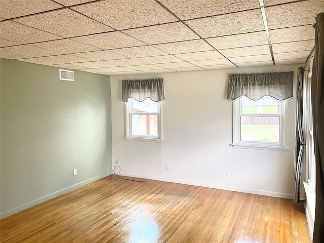 empty room with visible vents, light wood finished floors, and baseboards
