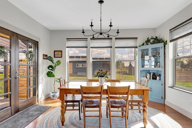 dining area with a chandelier, a healthy amount of sunlight, and wood finished floors