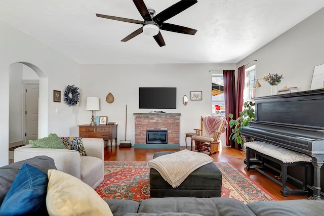 685 Hollibaugh Rd, Stevensville, MT 59870 - living room with ceiling fan, arched walkways, wood finished floors, and a brick fireplace