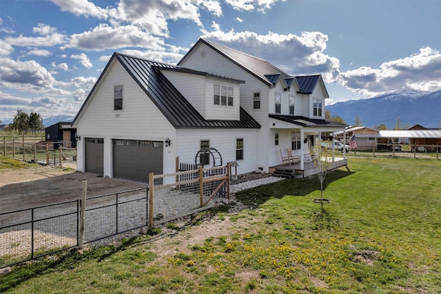 685 Hollibaugh Rd, Stevensville, MT 59870 - rear view of house featuring an attached garage, a fenced backyard, concrete driveway, a standing seam roof, and a metal roof