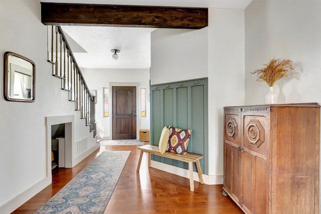 foyer entrance with stairs, baseboards, wood finished floors, and beamed ceiling