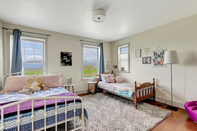 bedroom featuring baseboards and wood finished floors