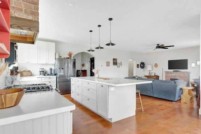 685 Hollibaugh Rd, Stevensville, MT 59870 - kitchen featuring stainless steel fridge with ice dispenser, arched walkways, a ceiling fan, and light countertops