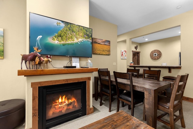 dining area with recessed lighting, carpet flooring, and a glass covered fireplace
