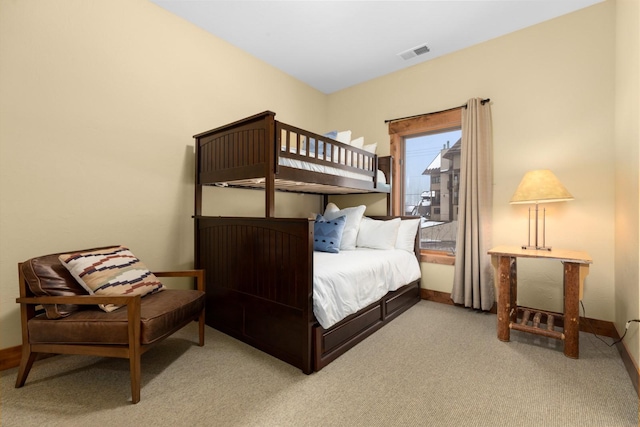bedroom with baseboards, light colored carpet, and visible vents