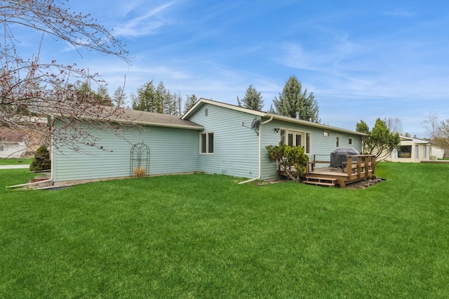 rear view of property with a lawn and a deck