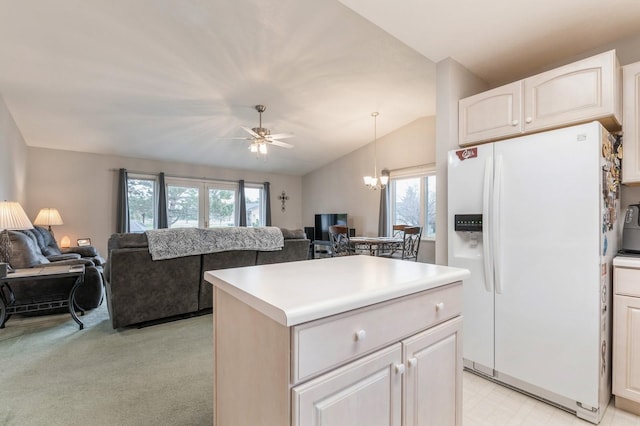 kitchen featuring a kitchen island, open floor plan, white fridge with ice dispenser, and ceiling fan with notable chandelier