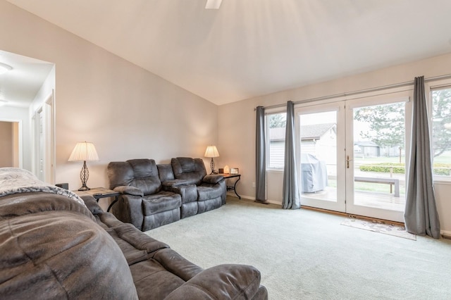 carpeted living area with baseboards and lofted ceiling
