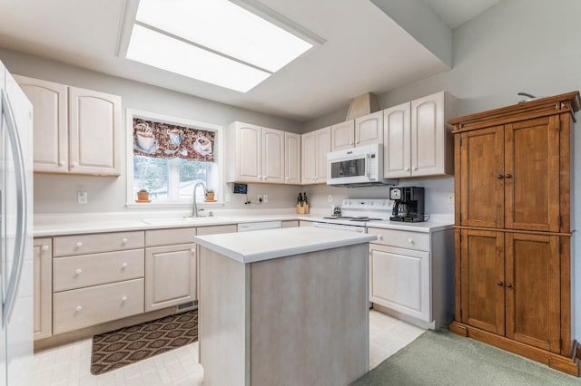 kitchen featuring a sink, a kitchen island, white appliances, and light countertops
