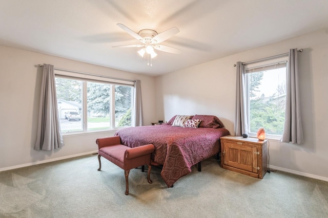 bedroom with light colored carpet, baseboards, and multiple windows