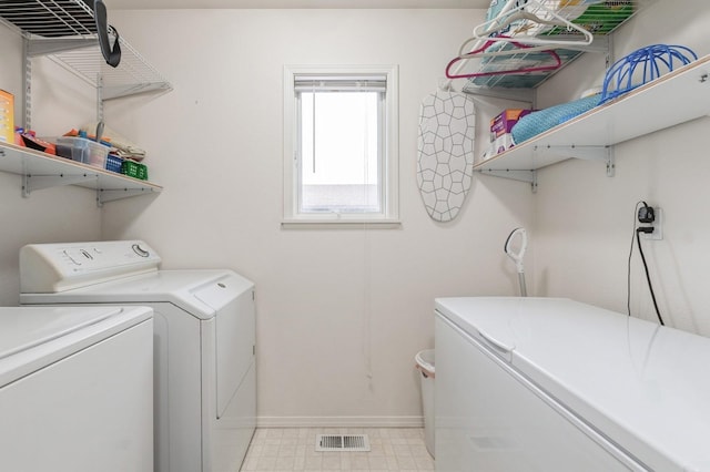 clothes washing area featuring baseboards, laundry area, independent washer and dryer, and visible vents