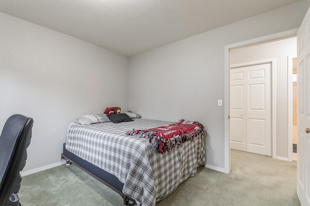 bedroom with light colored carpet and baseboards