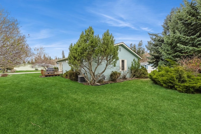 view of property exterior with central air condition unit, a yard, and a deck