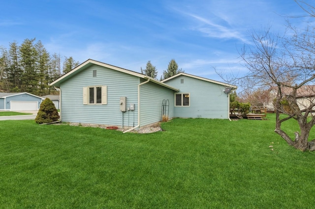 back of property featuring a lawn and a garage