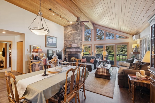 85 Golf Ter, Bigfork, MT 59911 - dining area featuring wood ceiling, an AC wall unit, wood finished floors, a stone fireplace, and a ceiling fan
