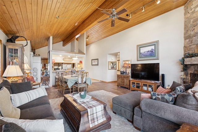 85 Golf Ter, Bigfork, MT 59911 - living area featuring vaulted ceiling, wooden ceiling, ceiling fan, rail lighting, and baseboards
