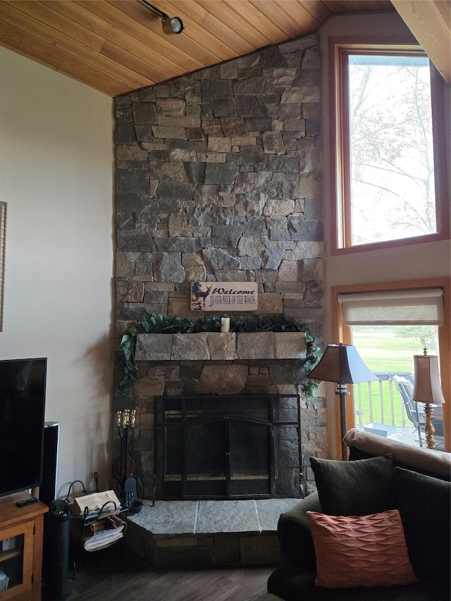 living room featuring a fireplace, lofted ceiling, a healthy amount of sunlight, and wooden ceiling