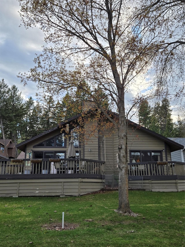 view of property exterior with a lawn and a wooden deck