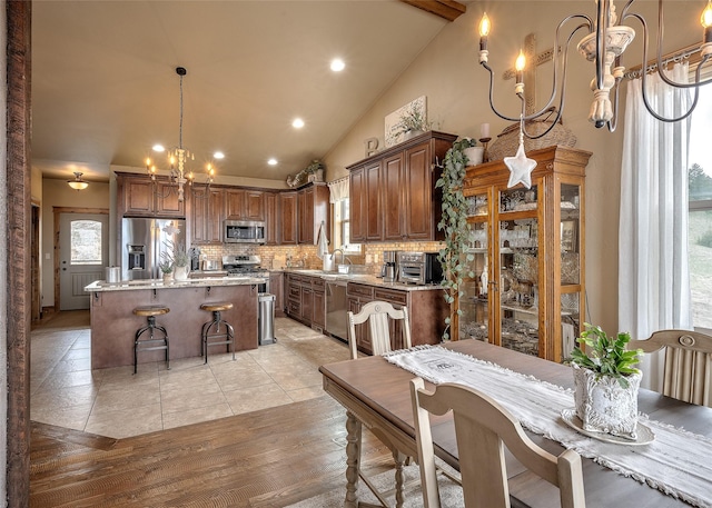 dining area with recessed lighting, high vaulted ceiling, and an inviting chandelier