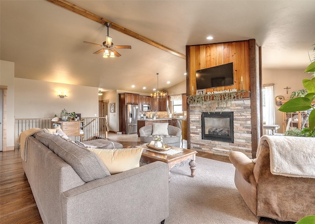 living area featuring a stone fireplace, recessed lighting, vaulted ceiling with beams, light wood-style flooring, and ceiling fan with notable chandelier