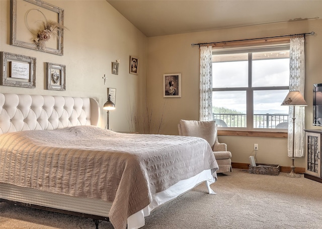 bedroom featuring vaulted ceiling, baseboards, and carpet flooring