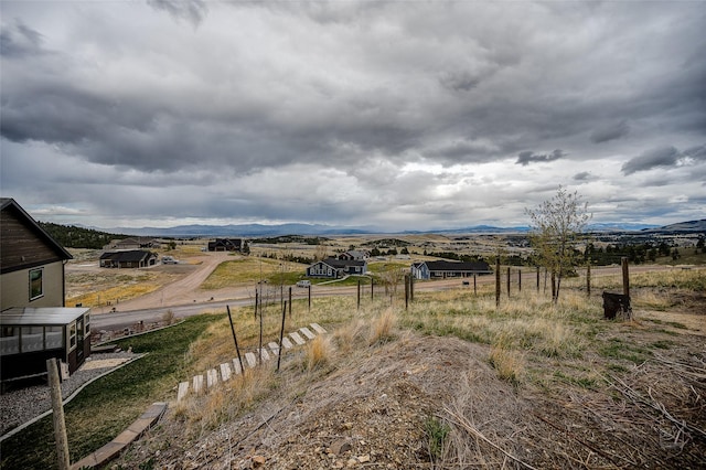 view of yard featuring a mountain view, a rural view, and fence