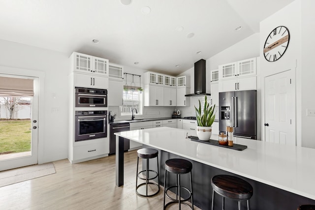 3201 12th St NE, Great Falls, MT 59404 - kitchen featuring wall chimney range hood, a sink, dishwashing machine, a breakfast bar, and high end fridge