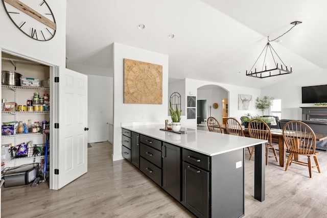 3201 12th St NE, Great Falls, MT 59404 - kitchen featuring a breakfast bar area, arched walkways, light countertops, lofted ceiling, and light wood-type flooring