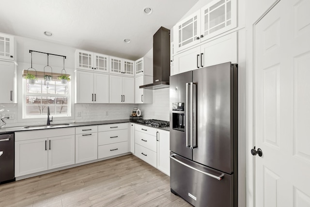 3201 12th St NE, Great Falls, MT 59404 - kitchen with appliances with stainless steel finishes, a sink, light wood-style floors, wall chimney exhaust hood, and decorative backsplash