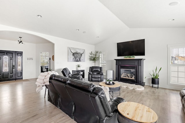 3201 12th St NE, Great Falls, MT 59404 - living room with a glass covered fireplace, arched walkways, light wood-type flooring, and lofted ceiling