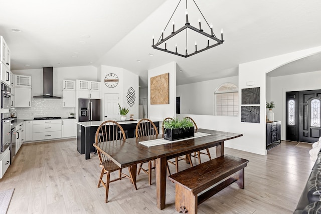 3201 12th St NE, Great Falls, MT 59404 - dining space with an inviting chandelier, arched walkways, vaulted ceiling, and light wood-type flooring