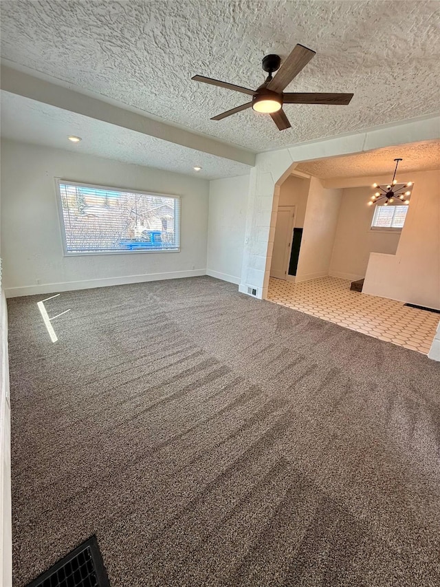 unfurnished living room with carpet floors, a ceiling fan, and a textured ceiling
