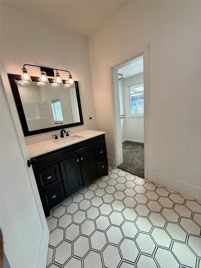 bathroom with vanity, baseboards, and tile patterned floors