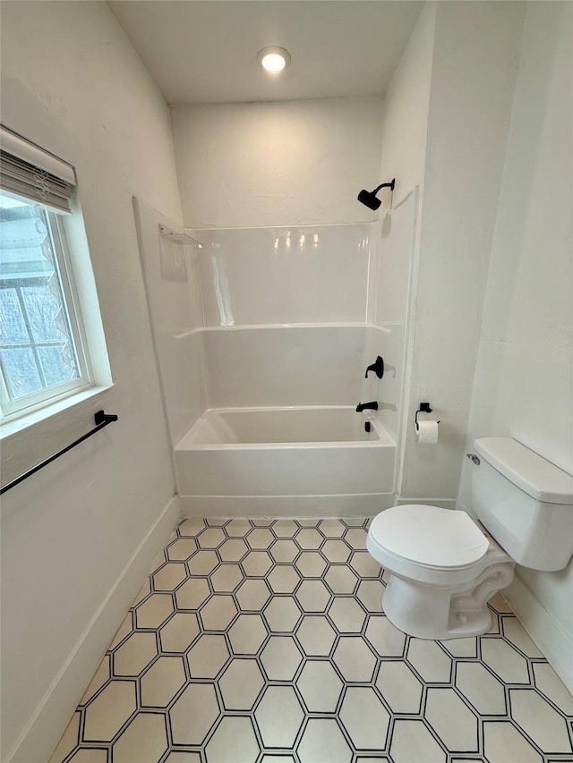 bathroom with toilet, baseboards, and bathtub / shower combination