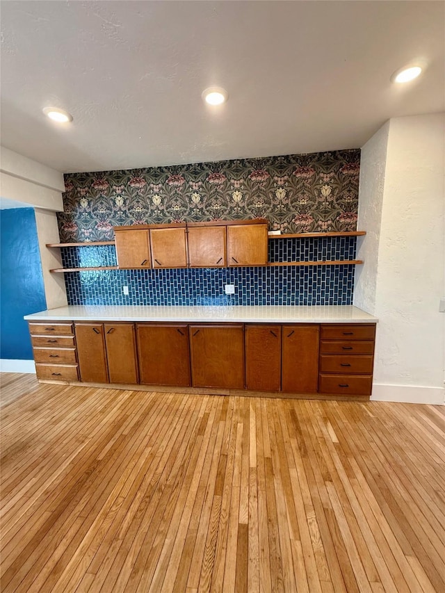 kitchen with open shelves, brown cabinetry, and light wood finished floors